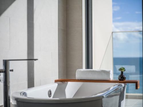 a bathroom with a bath tub with a laptop on a shelf at Crowne Plaza Phu Quoc Starbay by IHG in Phu Quoc