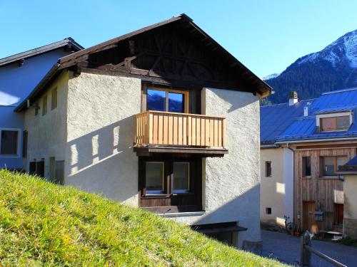 a house with a balcony on top of a hill at Chasa Tablà Guarda in Guarda
