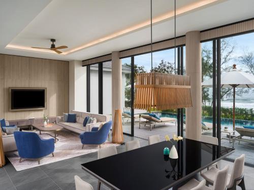 a living room with a table and blue chairs at Crowne Plaza Phu Quoc Starbay by IHG in Phu Quoc
