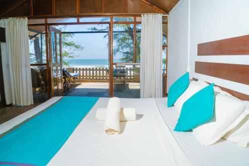 a bedroom with a bed with a view of the ocean at Peace Garden Beach Resort in Canacona