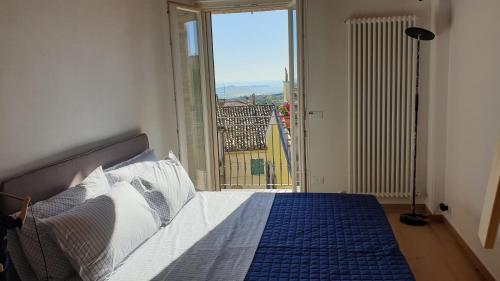 a bedroom with a bed with a view of a balcony at Aghèl Luxury Room in Recanati