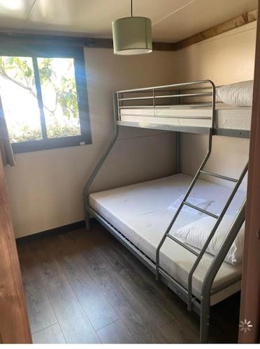 une chambre avec deux lits superposés et une fenêtre dans l'établissement Mobil home Chalet 35 m2 camping l ile d or Saint-raphael, à Saint-Raphaël
