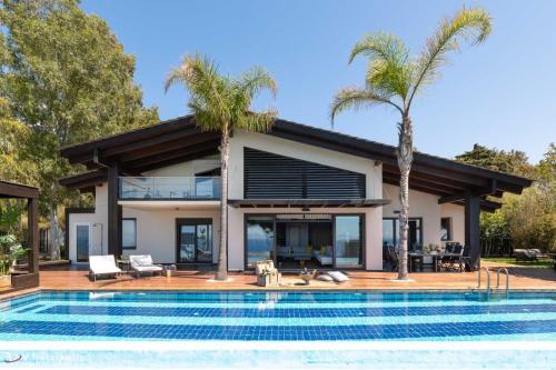 una casa con piscina y palmeras en Villa Equinox, en Ixia
