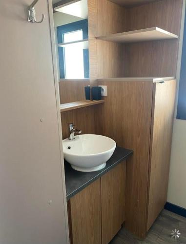 La salle de bains est pourvue d'un lavabo blanc sur un comptoir. dans l'établissement Mobil home Chalet 35 m2 camping l ile d or Saint-raphael, à Saint-Raphaël