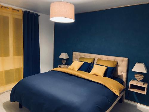 - une chambre bleue avec un grand lit aux murs bleus dans l'établissement Bleu Horizon, à Quiberville