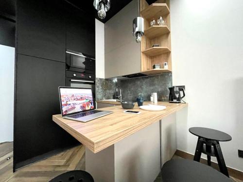 a kitchen with a counter with a laptop on it at Icon Apartaments Drobnera studio in Wrocław