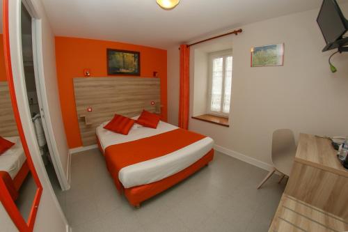 サン・ポル・ド・レオンにあるHotel Du Cheval Blancのオレンジ色の壁のベッドルーム1室、ベッド1台(オレンジ色の枕付)