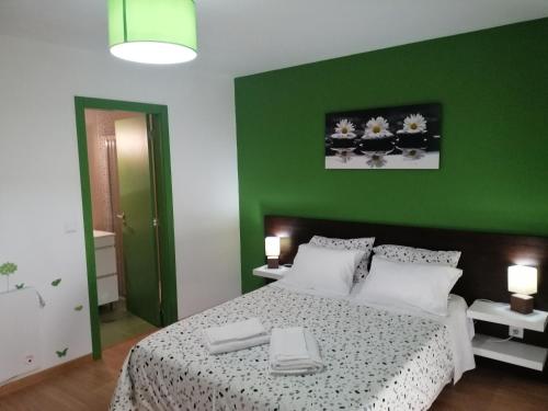 um quarto com uma cama com uma parede verde em Casa do Adro - Serra da Estrela em Cortes do Meio