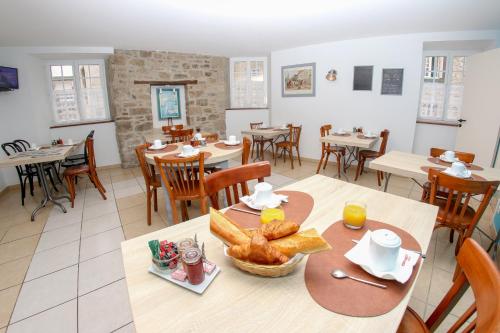 a dining room with a table with bread on it at Hotel Du Cheval Blanc in Saint-Pol-de-Léon