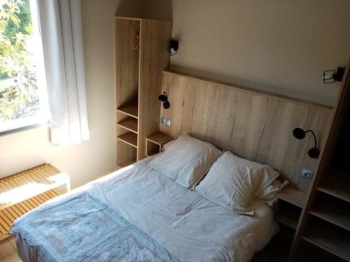 1 dormitorio con 1 cama con cabecero de madera en "Le Pigeonnier" chambre d'hôte, en Piégros-la-Clastre