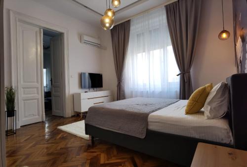 ein Schlafzimmer mit einem Bett und einem TV in der Unterkunft ZEN Apartments Oradea in Oradea