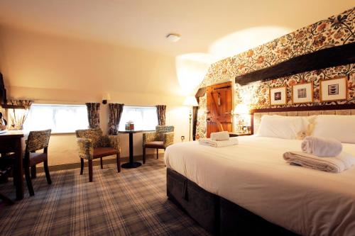a hotel room with a large bed and a desk at The Black Swan - The Inn Collection Group in Helmsley