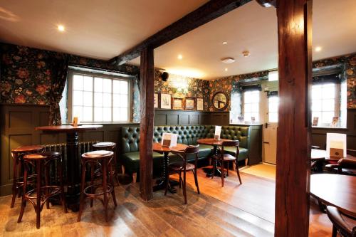 um bar com cadeiras verdes e mesas num restaurante em The Black Swan - The Inn Collection Group em Helmsley