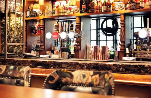 a bar with two chairs in front of a counter at The Black Swan - The Inn Collection Group in Helmsley