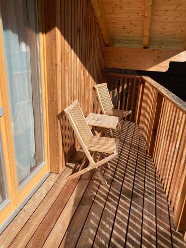 two chairs sitting on the porch of a cabin at Seehotel am Hallstättersee modern rooms in Obertraun