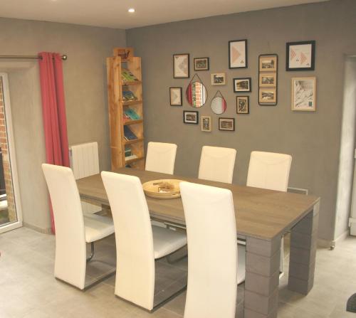 een eetkamer met een tafel en witte stoelen bij Les Gites d'Olloy - Le Beauséjour in Olloy-sur-Viroin