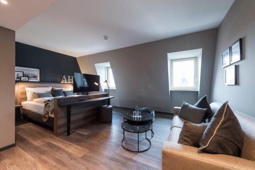 a bedroom with a bed and a desk and a couch at HARBR Hotel Ludwigsburg, a member of Radisson Individuals in Ludwigsburg
