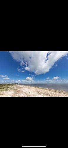 a picture of a beach with a blue sky and clouds at Holiday Park Caravan Fluffy in Harts Holiday Park in Leysdown-on-Sea