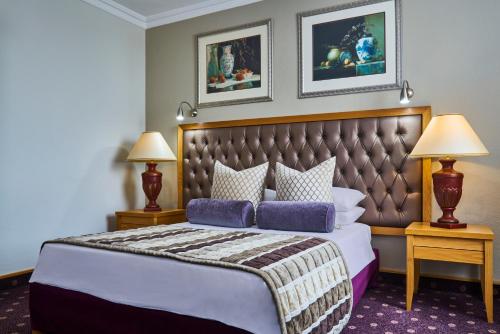 - une chambre avec un grand lit et deux lampes dans l'établissement Mövenpick Hotel Windhoek, à Windhoek