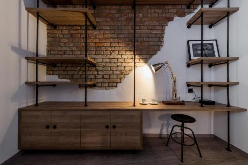 a desk in a room with a brick wall at Apartmánový dům U Tomana in Brno