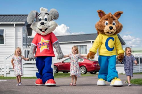 two mascots and a group of children holding hands at Holiday Park Caravan Fluffy in Harts Holiday Park in Leysdown-on-Sea