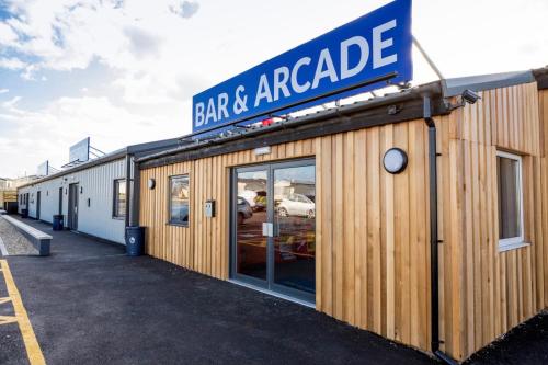 a restaurant with a sign that reads bar and arcade at Holiday Park Caravan Fluffy in Harts Holiday Park in Leysdown-on-Sea