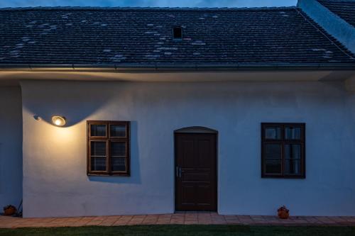 a white house with a black door and windows at Tschardakenhof Appartements in Lutzmannsburg