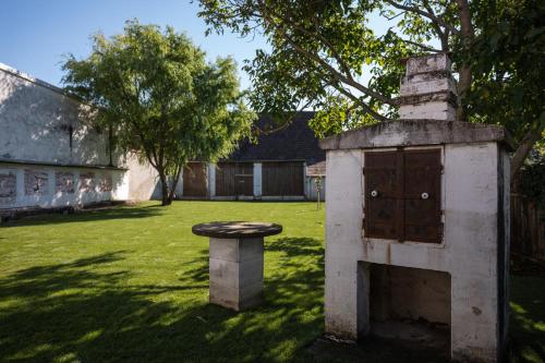 a stone oven and a stool in a yard at Tschardakenhof Appartements in Lutzmannsburg