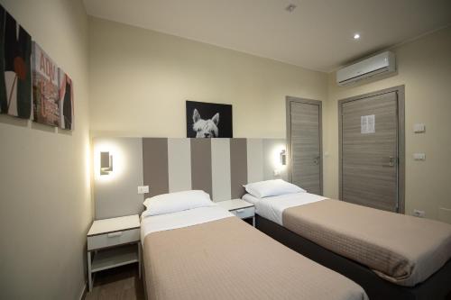 a hotel room with two beds and a striped wall at Le PALME in Parma