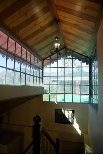 a staircase in a house with windows and a ceiling at AMBIKA HOME STAY in Solan