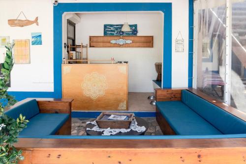 Zimmer mit blauen Wänden und blauen Bänken in der Unterkunft Casa da Mata SurfHouse in Costa da Caparica