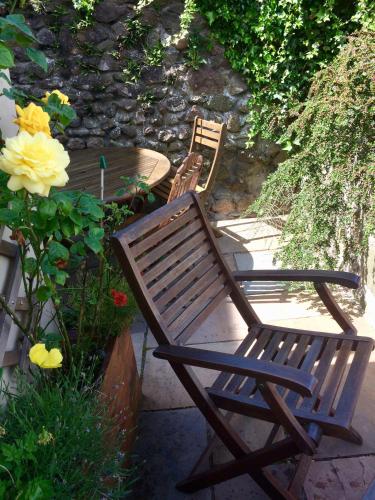 two wooden chairs sitting next to a table and flowers at Woolly Hill House - Beautiful Townhouse in the Heart of Wooler in Wooler