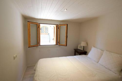 1 dormitorio con cama blanca y ventana en Apartament Central amb terrassa, en Alp