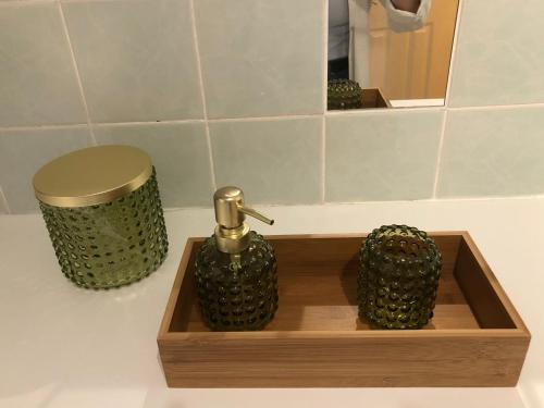 a bathroom counter with a wooden tray with a perfume bottle at The Blair Street Residence in Edinburgh