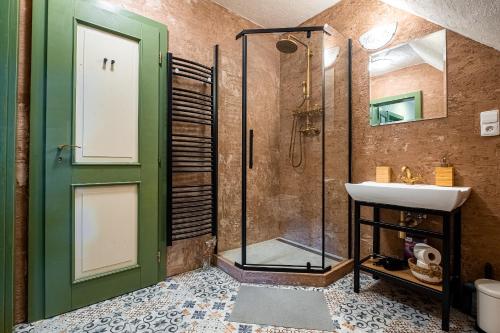 a bathroom with a glass shower and a sink at Penzion Betlém in Hlinsko
