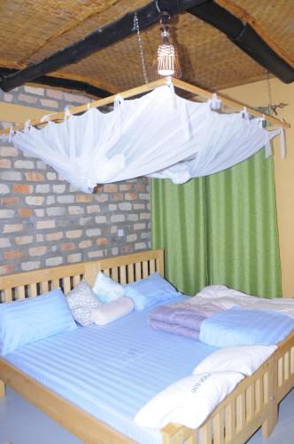 a bedroom with two beds with a canopy at Muga Eco Village in Ntungamo