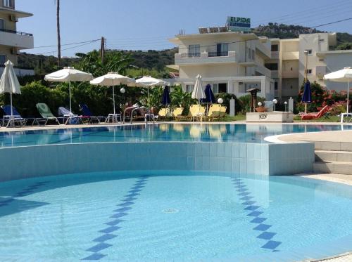a large swimming pool in front of a building at Elpida Beach Studios in Faliraki