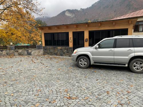 a silver van parked in front of a house at Hotel Patriot in Mestia