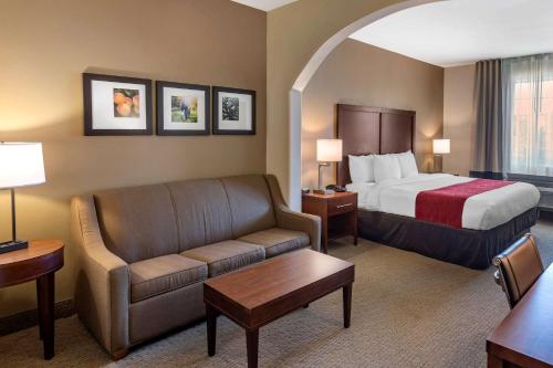 a hotel room with a bed and a couch at Comfort Inn & Suites Villa Rica in Villa Rica