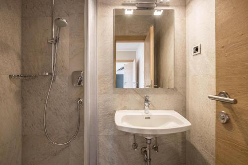 a bathroom with a sink and a shower with a mirror at Apt Hofer Barbara in Villabassa