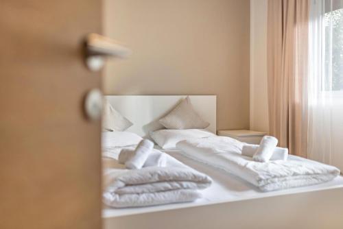 1 cama con espejo y toallas en Apt Hofer Sandra, en Villabassa