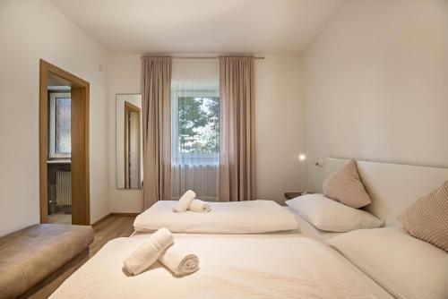 a bedroom with two beds and a couch at Apt Hofer Sandra in Villabassa