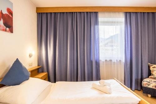 um quarto de hotel com uma cama e uma janela em Apt Hofer Monika em Villabassa
