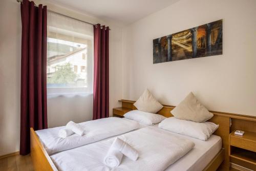 two beds in a room with a window at Apt Hofer Maria in Villabassa
