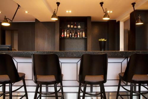 a bar with black chairs in a restaurant at Fosshotel Baron in Reykjav&iacute;k