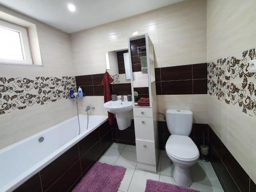 a bathroom with a toilet and a sink and a bath tub at Chalupa Margareta in Telgárt