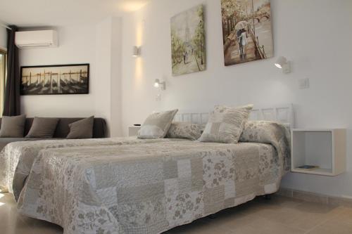 Dormitorio blanco con cama con manta en Estudio Luxury Primera Linea de Playa Almuñecar Parking Gratuito, en Almuñécar