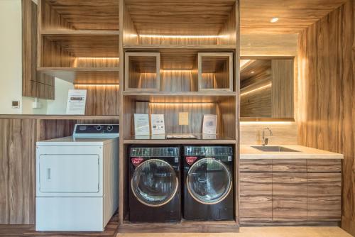 a kitchen with two washing machines and a sink at Ashley Wahid Hasyim Jakarta in Jakarta