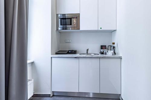 a kitchen with white cabinets and white appliances at The Levante Rathaus Apartments in Vienna