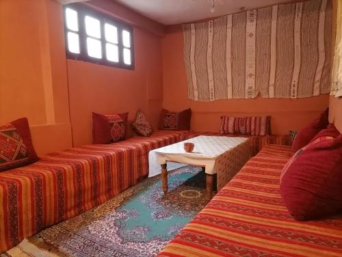 a living room with two beds and a table at Gîte Tamsoulte in Imlil